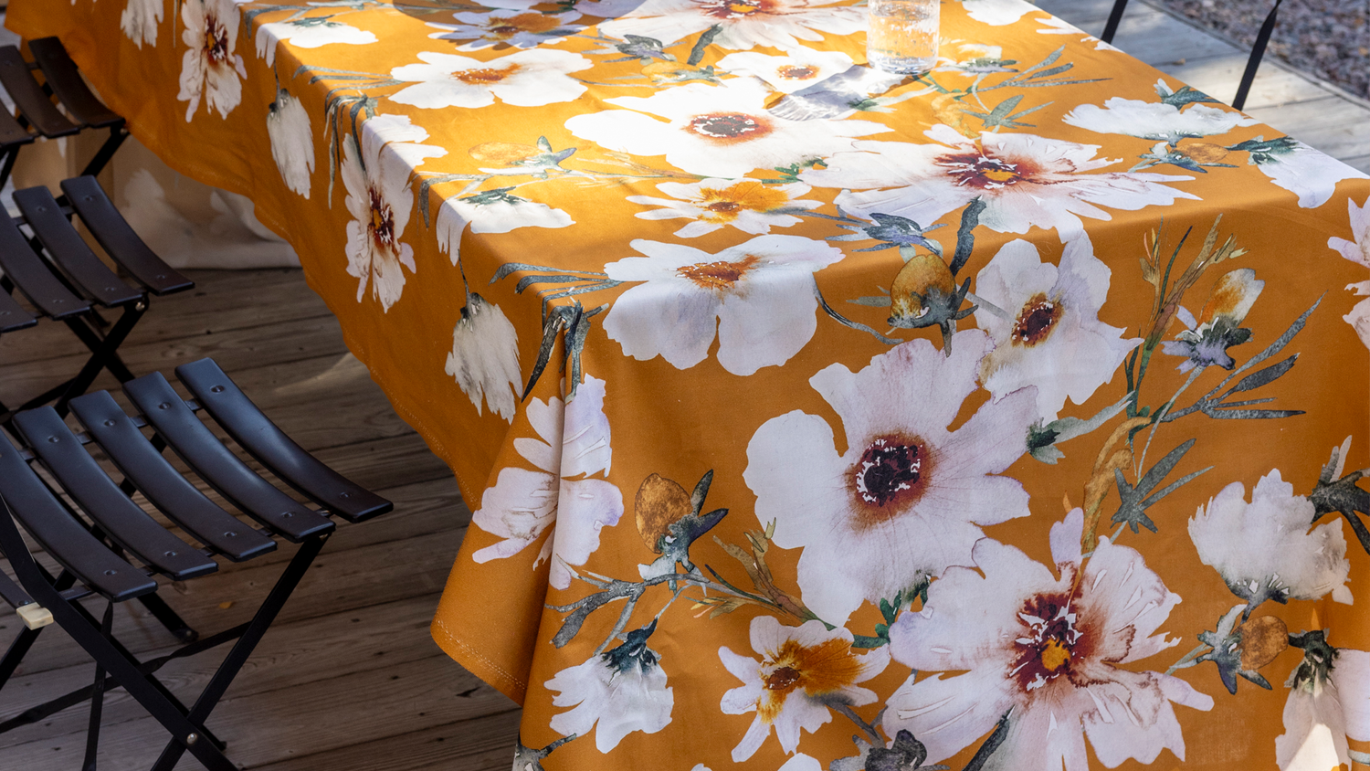 Yellow floral canvas on table surrounded by black patio chairs
