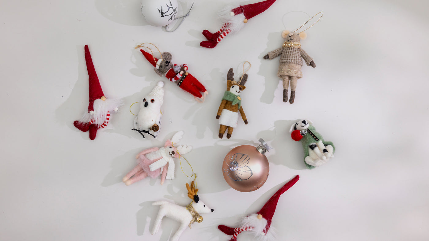 Collection of small Christmas ornaments on a white background. Redirects to ornaments and wreaths product collection.